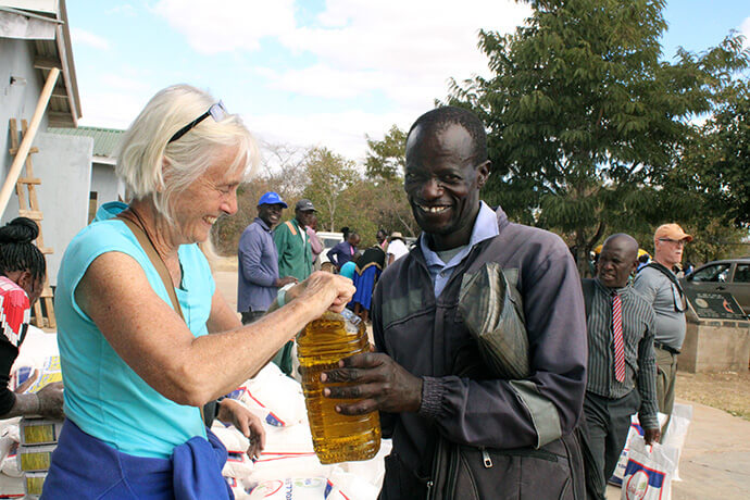 Mary Beth Zollars hands out food at Nyadire Mission in Mutoko, Zimbabwe. Zollars led a team of 10 volunteers from The Nyadire Connection in Pittsburgh who visited the church mission in June to help distribute food supplies. Photo by Kudzai Chingwe, UM News.