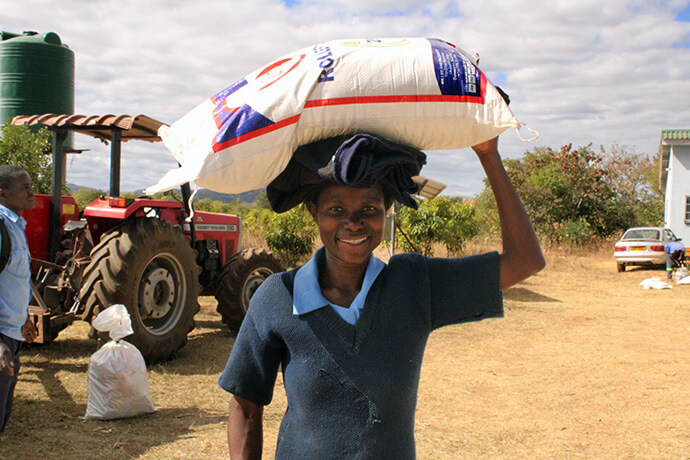Ruth Mukombwe, general hand, carries a bag of food at The United Methodist Church’s Nyadire Mission in Mutoko, Zimbabwe. She said she is grateful for the food relief provide by The Nyadire Connection. “This will go a long way in alleviating our suffering.” Photo by Kudzai Chingwe, UM News.