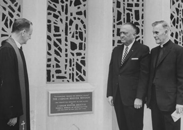 J. Edgar Hoover (centro), diretor do FBI, fica ao lado de uma placa dedicando um grande vitral a ele na Igreja Metodista Capitol Hill, hoje chamada Igreja Metodita Unida Capitol Hill, em 26 de junho de 1966. Também na foto estão o Rev. Edward B. Lewis (esquerda), pastor da igreja, e o Rev. Frederick Brown Harris (direita), capelão do Senado. A janela está programada para ser rededicada em 29 de setembro para diminuir a conexão com Hoover, cuja casa de longa data ficava no que hoje é o estacionamento da igreja. Foto cortesia da IMU Capitol Hill.   J. Edgar Hoover (centro), diretor do FBI, fica ao lado de uma placa dedicando um grande vitral a ele na Igreja Metodista Capitol Hill, hoje chamada Igreja Metodita Unida Capitol Hill, em 26 de junho de 1966. Também na foto estão o Rev. Edward B. Lewis (esquerda), pastor da igreja, e o Rev. Frederick Brown Harris (direita), capelão do Senado. A janela está programada para ser rededicada em 29 de setembro para diminuir a conexão com Hoover, cuja casa de longa data ficava no que hoje é o estacionamento da igreja. Foto cortesia da IMU Capitol Hill.