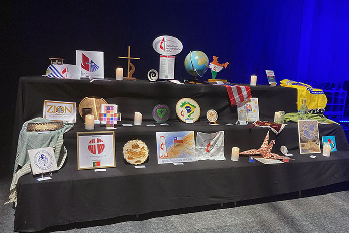 Pictured are symbols representing each of the Wesleyan-rooted denominations with participants at the World Methodist Conference. Photo by Heather Hahn, UM News.