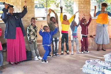 Florence Kachingwe (left, in pink skirt), chairperson of The Class of 81 Charitable Foundation, sings and dances with kids at Fairfield Children’s Home, a United Methodist-affiliated children’s home in Mutare, Zimbabwe. The foundation, started by former students at United Methodist Hartzell High School, donated food and other supplies to the school. Photo by Tafadzwa Gumbochuma. Florence Kachingwe (left, in pink skirt), chairperson of The Class of 81 Charitable Foundation, sings and dances with kids at Fairfield Children’s Home, a United Methodist-affiliated children’s home in Mutare, Zimbabwe. The foundation, started by former students at United Methodist Hartzell High School, donated food and other supplies to the school. Photo by Tafadzwa Gumbochuma.