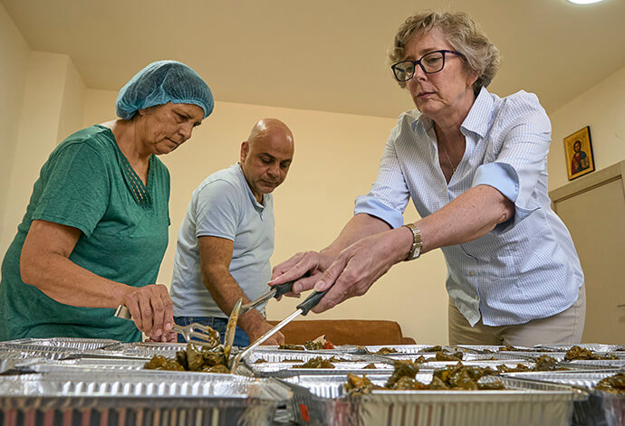 The Rev. Jane Eesley (right) helps Amal Qumsieh and Ramzi Qubrosi divide food into portions to be distributed to hungry people in the Bethlehem area by the Shepherd Society, the outreach program of Bethlehem Bible College. The program received a solidarity grant from the United Methodist Committee on Relief, helping Palestinians cope with the economic effects of the Israeli war on Gaza, which has scared away the tourists who are the motor of Bethlehem's economy. Photo by Paul Jeffrey, UM News.