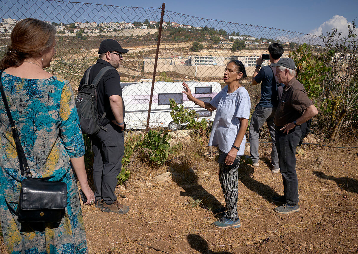 Amal Nassar shows a visiting delegation of U.S. church activists a trailer that has been moved onto land beside her family farm near Bethlehem. Known as the Tent of Nations, the farm is an educational and environmental center that sits on the last remaining Palestinian hilltop in the middle of the Gush Etzion settlement block near Bethlehem, in the occupied West Bank. The Christian Palestinian family remains under constant threat from settlers and the Israeli military. The trailer was moved there in May 2024, in what Nassar believes is an attempt to establish justification for expelling the Christian family. Photo by Paul Jeffrey, UM News.