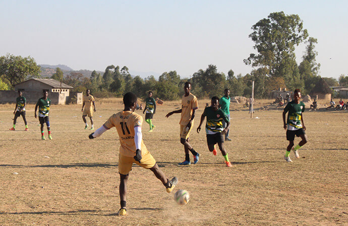 Les équipes de football Hwedza United (en uniforme beige) et Dendenyore Red Stars (en uniforme vert) s'affrontent lors d'un match à Wedza, au Zimbabwe. L'Église Méthodiste Unie St James Hwedza a constaté que le programme sportif était un outil d'évangélisation efficace. Photo par Kudzai Chingwe, UM News.