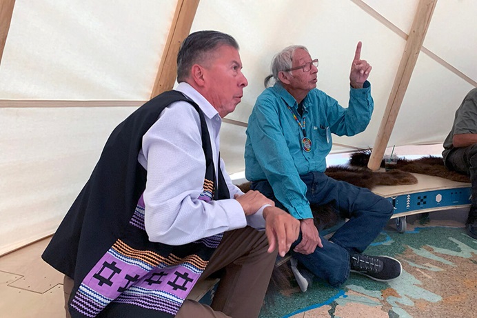 Great Plains Conference Bishop David Wilson, left, and Eugene Ridgely Jr., a Sand Creek representative of the Northern Arapaho tribe, gather in an Arapaho tipi located at the History Colorado Center in Denver. Both men are part of the United Methodist Responses to the Sand Creek Massacre Team, which met Sept. 20-21 at Iliff School of Theology to formulate next steps in the denomination’s work to atone for its role in the 1864 Sand Creek Massacre. Photo by Joey Butler, UM News. Great Plains Conference Bishop David Wilson, left, and Eugene Ridgely Jr., a Sand Creek representative of the Northern Arapaho tribe, gather in an Arapaho tipi located at the History Colorado Center in Denver. Both men are part of the United Methodist Responses to the Sand Creek Massacre Team, which met Sept. 20-21 at Iliff School of Theology to formulate next steps in the denomination’s work to atone for its role in the 1864 Sand Creek Massacre. Photo by Joey Butler, UM News.