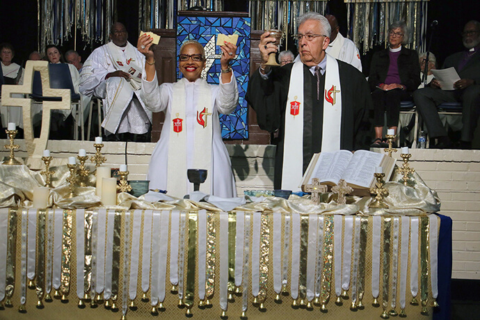 Council of Bishops President Tracy S. Malone (left) and President-Designate Bishop Ruben Saenz Jr. officiate at Holy Communion during the bishops’ memorial service on Nov. 3, All Saints Sunday, at Epworth by the Sea Conference Center in St. Simons Island, Ga. Malone is presiding at her first Council of Bishops meeting since taking office in May. The bishops are hoping to guide The United Methodist Church as it seeks to let go of past acrimony and maintain unity across multiple nations, cultures and theological perspectives. Photo by Rick Wolcott, Council of Bishops.