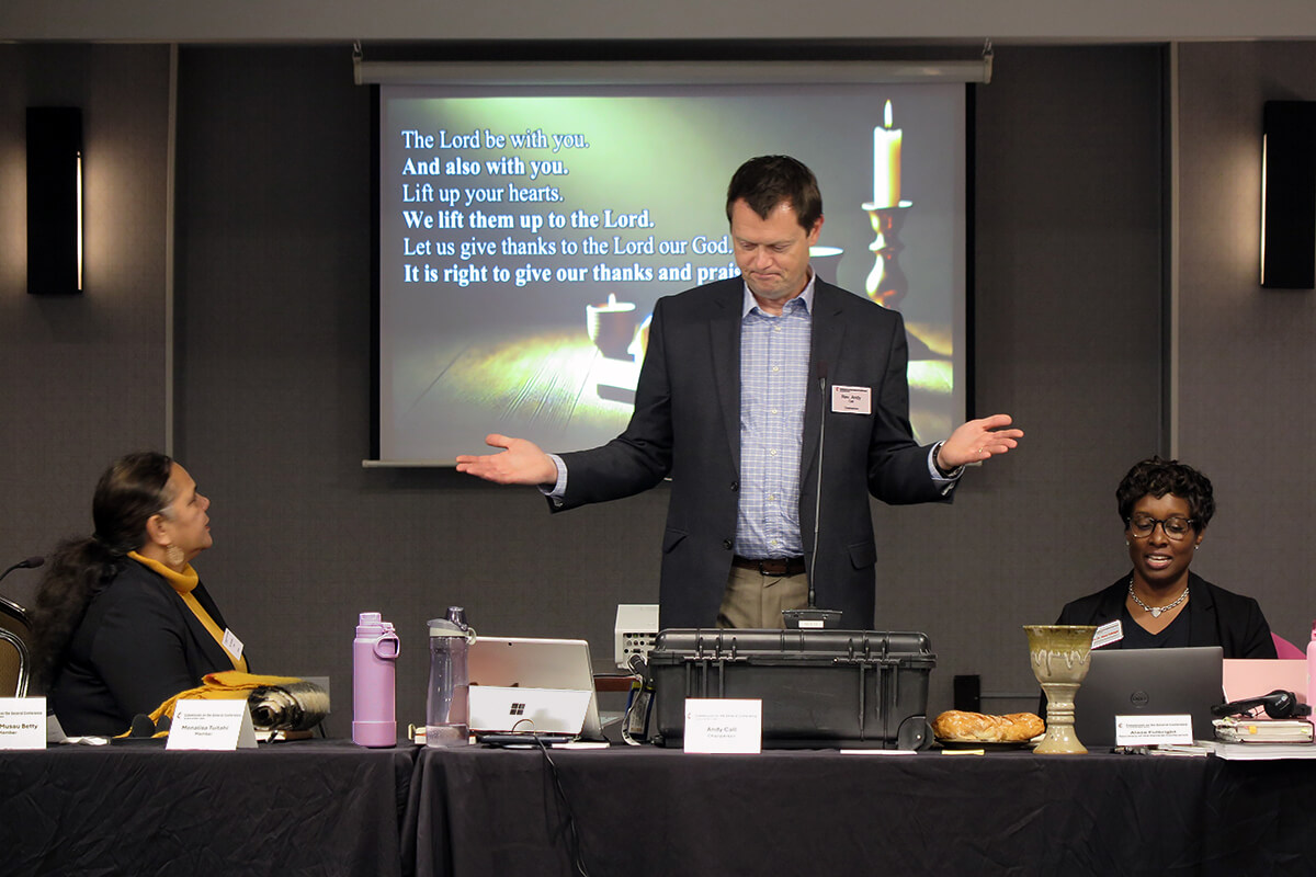 Le Révérend Andy Call, président de la Commission de la Conférence Générale, aide à diriger la Sainte Communion pendant le culte d'ouverture le 19 novembre lors de la réunion de la Commission de la Conférence Générale à Charlotte, N.C. Assis à côté de Call, Monalisa Tui'tahi (à gauche), vice-présidente de la Commission, et le Révérend Aleze M. Fulbright (à droite), le nouveau secrétaire de la Conférence Générale. Au cours de la réunion, la Commission a commencé à préparer la prochaine réunion de la plus haute assemblée législative de l'Église Méthodiste Unie, prévue en 2028. Photo par Heather Hahn, UM News.