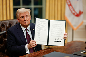 President Donald Trump holds up an executive order in the Oval Office at the White House on Inauguration Day in Washington. Trump signed a wave of executive orders in his first week of office, including revoking a policy that prohibited arrests by U.S. immigration agents at places of worship and other “sensitive locations.” Photo by Daniel Torok, White House.