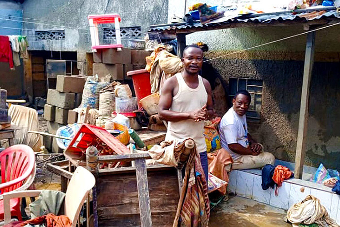 John Kodjo (standing), a member of Mapamboli United Methodist Church in Kinshasa, Congo, tries to salvage things from his flooded home. Torrential rains and flooding on April 5 damaged over 1,000 homes in the area and killed at least 33 people. Kodjo’s family fled on the roof of their home. Photo by the Rev. Fiston Okito, UM News.