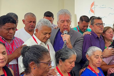 Bishop Rubén Saenz (center) prays for delegates to the annual meeting of the United Methodist Mission in Honduras during the closing session on March 18 in Tegucigalpa, Honduras. Saenz is the mission’s newly appointed episcopal leader. Photo by the Rev. Gustavo Vasquez, UM News. Bishop Rubén Saenz (center) prays for delegates to the annual meeting of the United Methodist Mission in Honduras during the closing session on March 18 in Tegucigalpa, Honduras. Saenz is the mission’s newly appointed episcopal leader. Photo by the Rev. Gustavo Vasquez, UM News.