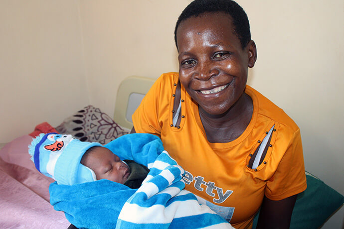 Sarah Mushamba holds her baby, Clarence Rinomhota, on Feb. 21 at the newly renovated Chindenga clinic. Photo by Kudzai Chingwe, UM News.