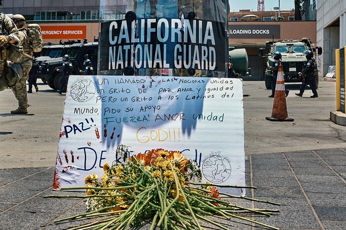 A National Guardsman stands watch at a June 10 prayer vigil organized by the United Methodist-founded Clergy and Laity United for Economic Justice in downtown Los Angeles. The participants placed in front of him a poster in Spanish calling for peace, love and equality and asking for support. United Methodists across the Los Angeles area are working to stand up for immigrant rights while trying to de-escalate a tense situation as the Trump administration has deployed National Guard troops and Marines to quell protests against U.S. Immigration and Customs Enforcement. Photo courtesy of Clergy and Laity United for Economic Justice. A National Guardsman stands watch at a June 10 prayer vigil organized by the United Methodist-founded Clergy and Laity United for Economic Justice in downtown Los Angeles. The participants placed in front of him a poster in Spanish calling for peace, love and equality and asking for support. United Methodists across the Los Angeles area are working to stand up for immigrant rights while trying to de-escalate a tense situation as the Trump administration has deployed National Guard troops and Marines to quell protests against U.S. Immigration and Customs Enforcement. Photo courtesy of Clergy and Laity United for Economic Justice.