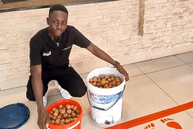 Africa University graduate Panashe Banda displays buckets of mazhanje, an African wild fruit, he brought as a gift to the Zimbabwe West Conference head office staff. Banda has been sharing his family’s harvest with the staff each year as a thank you for the church scholarship he received to attend the United Methodist university in Mutare, Zimbabwe. Photo by Chenayi Kumuterera, UM News. Africa University graduate Panashe Banda displays buckets of mazhanje, an African wild fruit, he brought as a gift to the Zimbabwe West Conference head office staff. Banda has been sharing his family’s harvest with the staff each year as a thank you for the church scholarship he received to attend the United Methodist university in Mutare, Zimbabwe. Photo by Chenayi Kumuterera, UM News.
