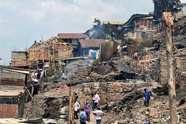 Kashalile Bony (right), a United Methodist from the Bethlehem Local Church in Kadutu, Congo, searches through the rubble of his burned-down house on Kaduru Avenue in Bukavu in eastern Congo. United Methodists are among nearly 1,500 families who lost their homes in a devastating fire on July 17. Photo courtesy of the Bukavu District. Kashalile Bony (right), a United Methodist from the Bethlehem Local Church in Kadutu, Congo, searches through the rubble of his burned-down house on Kaduru Avenue in Bukavu in eastern Congo. United Methodists are among nearly 1,500 families who lost their homes in a devastating fire on July 17. Photo courtesy of the Bukavu District.
