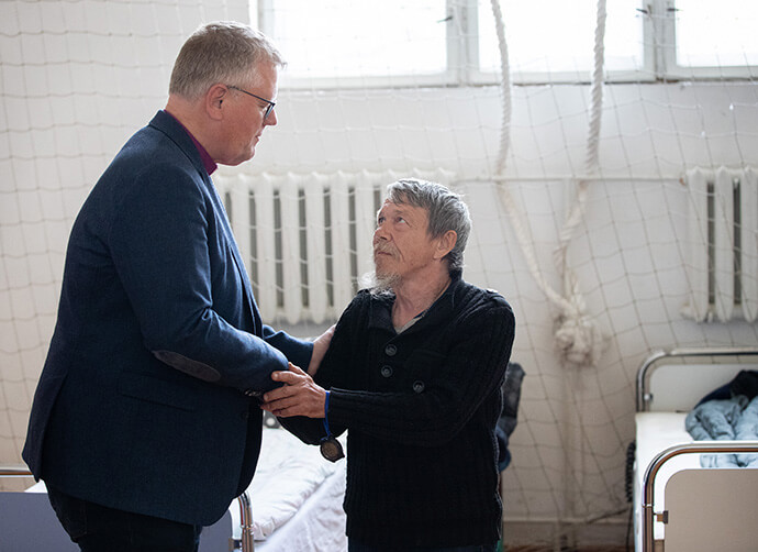 During a 2022 visit to Ukraine, United Methodist Bishop Christian Alsted visits with Alexandre, who is living in the gymnasium at the Onokivtsi Secondary School near Uzhhorod. Being present reassures victims of the war that the church has not forgotten them, Alsted said. File photo by Mike DuBose, UM News.