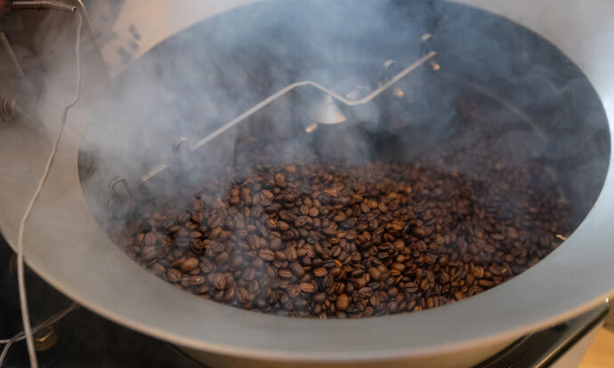 De la fumée s'élève des grains de café fraîchement torréfiés à Deep Time. Timothy Underwood explique qu'il a lancé une entreprise de nettoyage commercial et qu'il envisage de se lancer dans l'industrie du camionnage. Pour lui, le tournant s'est produit lorsqu'il a quitté l'emploi qu'il occupait à l'usine après sa sortie de prison pour rejoindre Deep Time. Photo de Mike DuBose, UM News.
