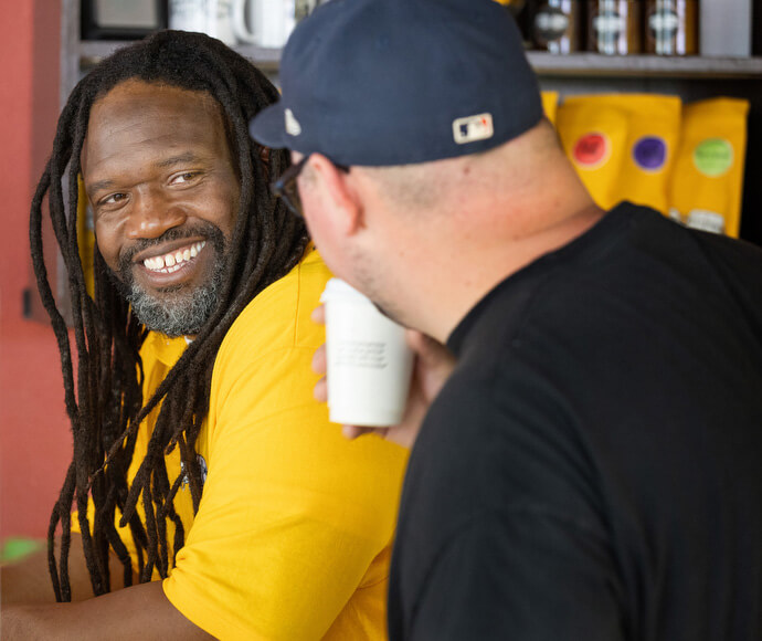 Timothy "GA" Underwood (à gauche) et le révérend Dustin Mailman discutent et sourient au Deep Time. Le ministère utilise le pouvoir de connexion d'une bonne tasse de café pour aider à créer un engagement avec les personnes touchées par l'incarcération.