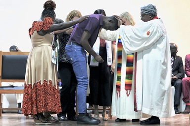 Steven Odhiambo of the Kenya-Ethiopia Conference is consecrated as a home missioner by retired United Methodist Bishop Joaquina F. Nhanala during the Africa Region Deaconess/Home Missioner consecration service on July 9 at the Lutheran Uhuru Hostel and Conference Centre in Moshi, Tanzania. The ceremony marked the first time a United Methodist deaconess/home missioner consecration was held on African soil. Photo courtesy of Laurel Akin. Steven Odhiambo of the Kenya-Ethiopia Conference is consecrated as a home missioner by retired United Methodist Bishop Joaquina F. Nhanala during the Africa Region Deaconess/Home Missioner consecration service on July 9 at the Lutheran Uhuru Hostel and Conference Centre in Moshi, Tanzania. The ceremony marked the first time a United Methodist deaconess/home missioner consecration was held on African soil. Photo courtesy of Laurel Akin.
