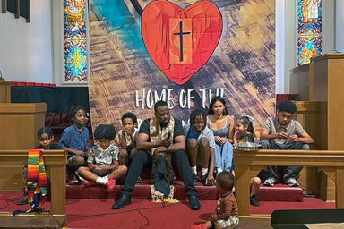 The Rev. J. Andre Wilson (center) shares a message with children during Altadena United Methodist Church’s first Sunday worship service at its new temporary home on the campus of the former First United Methodist Church of San Gabriel, Calif. Altadena is one of two United Methodist churches destroyed by wildfires in January. Photo courtesy of Heather Wilson. The Rev. J. Andre Wilson (center) shares a message with children during Altadena United Methodist Church’s first Sunday worship service at its new temporary home on the campus of the former First United Methodist Church of San Gabriel, Calif. Altadena is one of two United Methodist churches destroyed by wildfires in January. Photo courtesy of Heather Wilson.