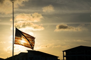 An American flag waves at half-staff in 2018 after the shooting at Marjory Stoneman Douglas High School in Parkland, Florida. Flags are standing at half-staff again after the Sept. 10 assassination of an activist on a university campus. United Methodist bishops are urging members to act as peacemakers to help put an end to the violence. Photo by Bryan Roschetzky, iStock. An American flag waves at half-staff in 2018 after the shooting at Marjory Stoneman Douglas High School in Parkland, Florida. Flags are standing at half-staff again after the Sept. 10 assassination of an activist on a university campus. United Methodist bishops are urging members to act as peacemakers to help put an end to the violence. Photo by Bryan Roschetzky, iStock.