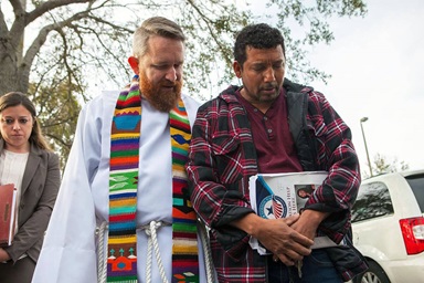 The Rev. Andy Oliver (left) of Allendale United Methodist Church in St. Petersburg, Fla.,  prays with Luis Blanco in front of the Tampa immigration office on Jan. 30, 2018. The congregation supported Blanco and his family during his deportation proceedings. Oliver continues to be in ministry with marginalized communities in Florida, including helping to lead weekly protests at detention centers in the state that are housing suspected undocumented immigrants. File photo courtesy of the Rev. Andy Oliver. The Rev. Andy Oliver (left) of Allendale United Methodist Church in St. Petersburg, Fla.,  prays with Luis Blanco in front of the Tampa immigration office on Jan. 30, 2018. The congregation supported Blanco and his family during his deportation proceedings. Oliver continues to be in ministry with marginalized communities in Florida, including helping to lead weekly protests at detention centers in the state that are housing suspected undocumented immigrants. File photo courtesy of the Rev. Andy Oliver.