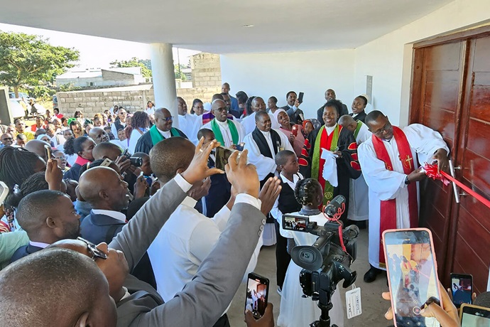 O Bispo João Filimone Sambo corta a fita na inauguração, em Julho, da nova capela permanente da Igreja Metodista Unida de Muhalaze, nos arredores de Maputo, Moçambique. O Campo Missionário de Muhalaze cresceu e agora conta com seis Igrejas Locais com mais de 300 membros, mas esta é a sua primeira estrutura permanente. Foto de Roque Facela, UM News. O Bispo João Filimone Sambo corta a fita na inauguração, em Julho, da nova capela permanente da Igreja Metodista Unida de Muhalaze, nos arredores de Maputo, Moçambique. O Campo Missionário de Muhalaze cresceu e agora conta com seis Igrejas Locais com mais de 300 membros, mas esta é a sua primeira estrutura permanente. Foto de Roque Facela, UM News.