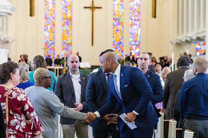 Maryland Gov. Wes Moore (center) shakes hands with worshippers at a Feb. 23 service at Silver Spring United Methodist Church in Silver Spring, Md. Moore’s administration announced Oct. 9 that the growing, multi-ethnic congregation has received tax credits and rental housing support to encourage investment in the church’s affordable-housing project. Photo by Alison Burdett, Baltimore-Washington Conference.