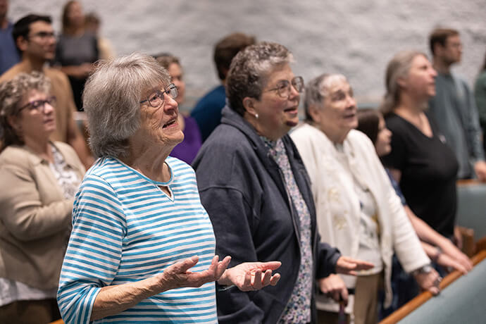 Irene Weesner (à gauche, au premier plan) chante pendant le culte à l'Eglise Méthodiste Elkhart Faith United Methodist Church. Mme Weesner était bénévole au sein du groupe de jeunes de l'église lorsque Frank Beard, aujourd'hui évêque, était adolescent. Photo de Mike DuBose, UM News.
