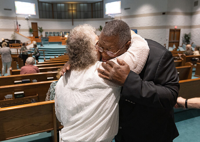 Vicki Bridensstein (à gauche) embrasse l'Evêque Frank Beard avant le culte à l'Eglise Méthodiste Elkhart Faith United Methodist Church. Elle dit connaître Beard depuis son adolescence. Photo de Mike DuBose, UM News.