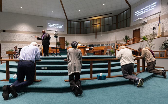 Les paroissiens et les invités répondent à l'appel à la conversion lancé par l'évêque Frank Beard (à l'arrière-plan) à l'Eglise Méthodiste Elkhart Faith United Methodist Church. Photo de Mike DuBose, UM News.