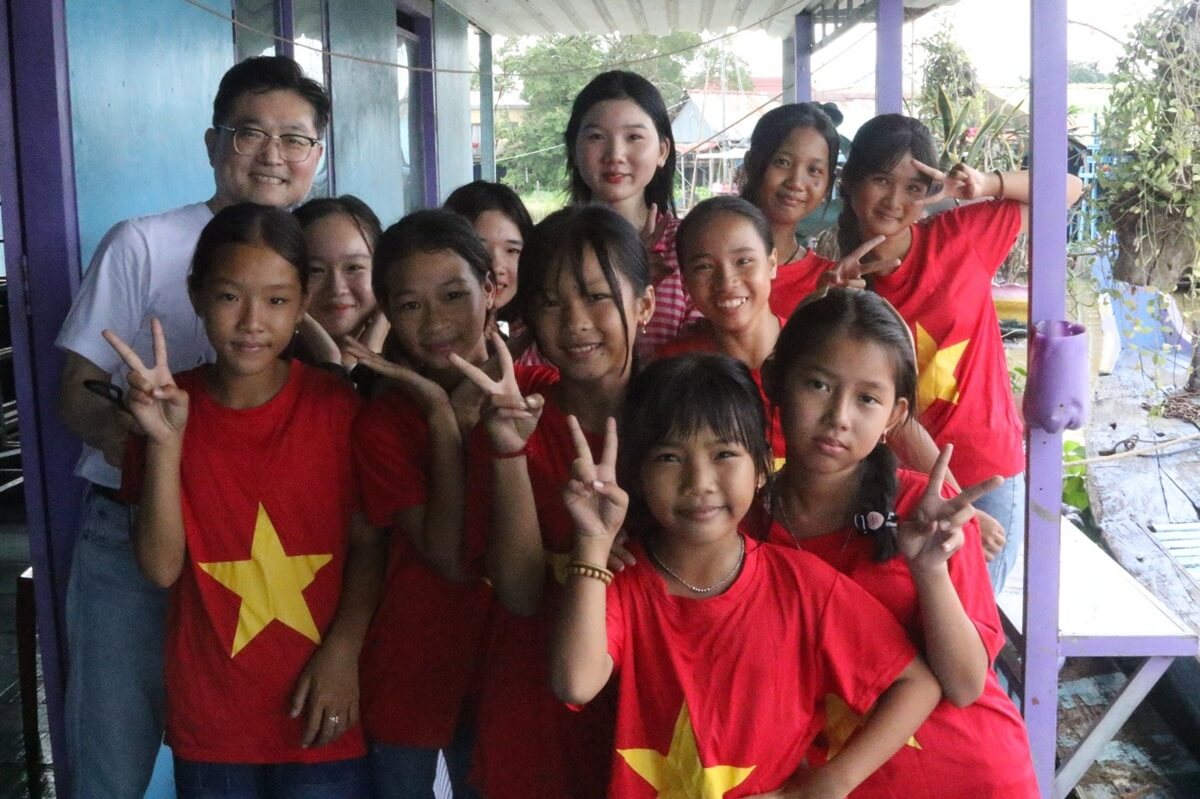 톤레삽강(Tonlé Sap River) 위에 있는 수상 마을의 아가페가든교회(Agape Garden Church)의 어린이들이 워쉬아카데미 참가자들을 반갑게 맞이하고 있다. 사진 뒷줄 왼쪽은 연합감리교회 세계선교부 아시아·태평양지역 대표인 폴 공(Paul Kong) 목사이다. 콩 목사는 “교회가 물탱크를 설치하고 보육 및 정수 시설을 제공하기 시작한 이후, 어린이 익사 사고가 단 한 건도 발생하지 않았습니다.”라고 말했다. 사진, 김응선(Thomas E. Kim) 목사, 연합감리교뉴스.