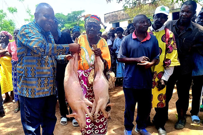 Sua Reverendíssima Bispo Moisés Bernardo Jungo, prestigia entrega simbólica de casal de suínos a Soba Maria Cadia, durante visita no circuito da Kimbamba, Distrito Eclesiástico do Quéssua, no encerramento da segunda fase do projecto Yambasu. Foto de João Nhanga, Notícias MU. 
