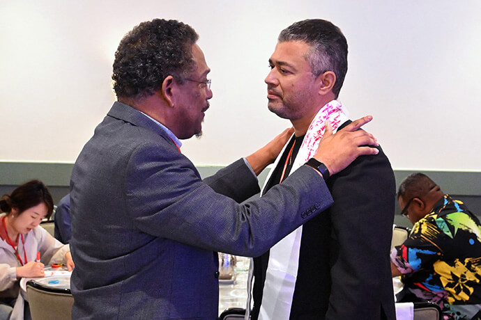 The Rev. Stephen Handy (left), who leads churches in downtown Nashville, Tenn., prays with a colleague Oct. 8 during the Facing the Future 2025 conference. Photo by Jim Patterson, UM News.