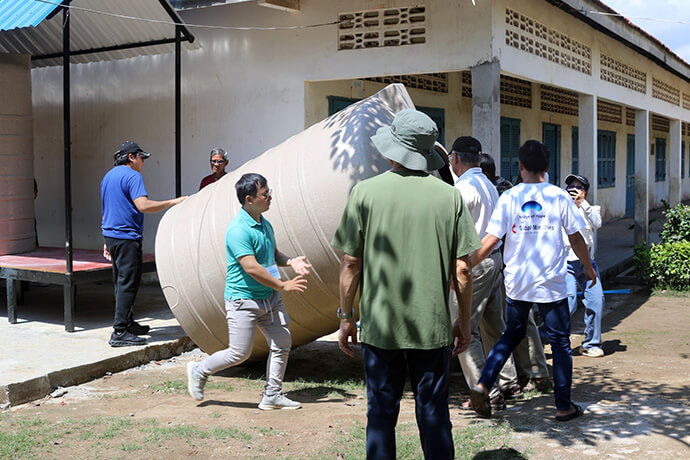 WASH Academy participants install rainwater-harvesting tanks Oct. 15 at Hun Sen Sa’ng High School in Phnom Penh, Cambodia. They set up four tanks with a combined capacity of 12,000 liters of rainwater to be converted into drinking water. Photo by the Rev. Thomas E. Kim, UM News.