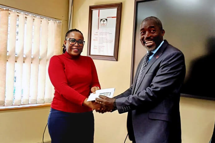 Professor Peter Mageto faz entrega do envelope com valores para a tesoureira da Universidade de África, na presença dos ex-estudantes, membros do seu gabinete e dos dois bispos das Conferências do Oeste e Leste de Angola na Universidade de África, em Mutare - Zimbabwe. Foto de João Nhanga, Noticias MU.