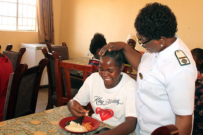 Sœur Florence Mefor, missionnaire auprès du Conseil méthodiste unifié des ministères mondiaux et sage-femme, discute avec une patiente qui déjeune à l'hôpital Old Mutare Mission au Zimbabwe. Grâce au travail de Mefor, les hôpitaux missionnaires de l'Église fournissent des repas quotidiens aux patientes en maternité. Photo de Kudzai Chingwe, UM News.