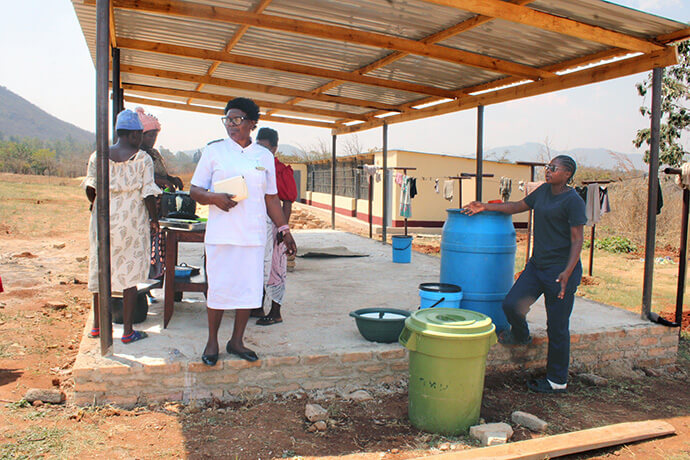 Des femmes enceintes reçoivent leur déjeuner à l'hôpital Old Mutare Mission au Zimbabwe. Sœur Florence Mefor (en uniforme blanc), missionnaire et sage-femme au sein de Global Ministries, a mis en place ce service de repas quotidiens après avoir constaté que de nombreuses femmes arrivaient à l'hôpital missionnaire de l'église sans avoir mangé et souffraient souvent de malnutrition ou d'anémie. Photo de Kudzai Chingwe, UM News.