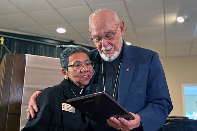 The Rev. Nohemí Ramírez congratulates retired Bishop Joel Martínez as he receives recognition during the 120th anniversary celebration of La Trinidad United Methodist Church in Seguin, Texas. The bishop was honored for his career as a denominational leader and a pillar of the congregation. Photo by the Rev. Gustavo Vasquez, UM News.