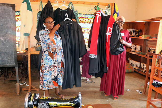 Godelieve Manirakiza (à gauche), coordinatrice nationale des femmes de la Conférence du Burundi, et Pascaline Nijimbere, Présidente des femmes de la Conférence, admirent des robes ecclésiastiques cousues par des élèves en couture et vendues au centre de formation des femmes de l'Église méthodiste unie de Nyabugogo. Photo d'Eveline Chikwanah, UM News.