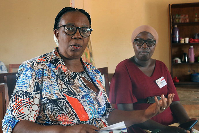 Godelieve Manirakiza (à gauche) explique le fonctionnement du centre de formation de l'Église méthodiste unie de Nyabugogo. Le centre propose des formations en couture aux membres de la communauté voisine, leur permettant ainsi de créer leur propre entreprise après avoir suivi les cours. Photo d'Eveline Chikwanah, UM News.