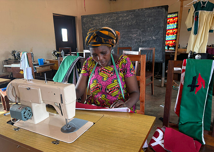 Fredienne Haganzimana, formatrice au Centre des femmes Méthodistes Unies de l'Église Méthodiste Unie de Nyabugogo à Gitega, au Burundi, coud des vêtements ecclésiastiques qui sont vendus pour financer les frais de fonctionnement du centre. Le centre forme des membres de la communauté locale à la couture de vêtements, d'uniformes scolaires et de vêtements ecclésiastiques. Photo d'Eveline Chikwanah, UM News.