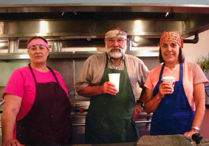 JuDee Anderson (left), Steve Magneson and Elsie Sanders of First United Methodist Church in Sheridan, Wyo., help prepare food at a gathering for saving Plains Indian Sign language. Their participation stems from a two-decade partnership between the church’s Native American Committee and the Northern Cheyenne of Lame Deer, Montana. File photo courtesy of First UMC Sheridan.