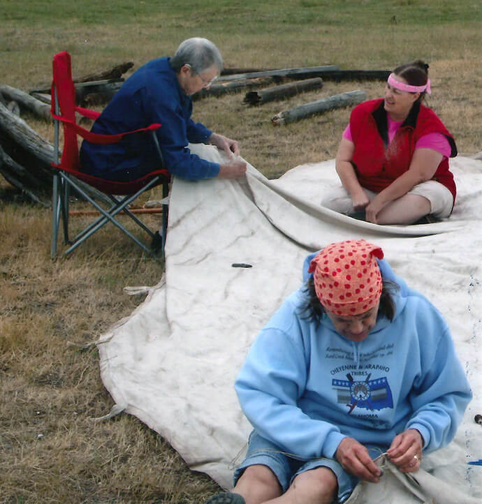 Dorothy Hackman (left), Elsie Sanders (foreground) and JuDee Anderson of First United Methodist Church in Sheridan, Wyo., repair a tipi that will be set up for them at a gathering for saving Plains Indian Sign language. Their participation stems from a two-decade partnership between the church’s Native American Committee and the Northern Cheyenne of Lame Deer, Montana. File photo courtesy of First UMC Sheridan.