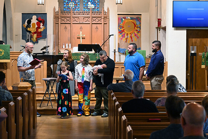 The Rev. Joe Graves (left) prepares to baptize the five members of the McKinley family (center) during Sept. 21 services at Cityview Church. Graves helped launch Cityview, a merger between his 2017 church start Central City Church and the more traditional St. Luke’s United Methodist Church. He’s also written a book on church planting, a priority of the East and West Ohio conferences. Photo by Jim Patterson, UM News.