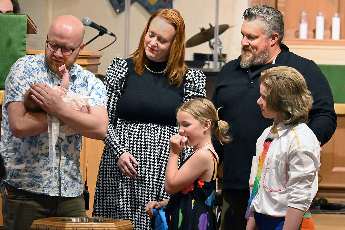 The Rev. Joe Graves (left) baptizes a baby Sept. 21 at Cityview Church. The rest of the McKinley family also were baptized during the service. Graves helped launch Cityview, a merger between his 2017 church start Central City Church and the more traditional St. Luke’s United Methodist Church. He’s also written a book on church planting, a priority of the East and West Ohio conferences. Photo by Jim Patterson, UM News.