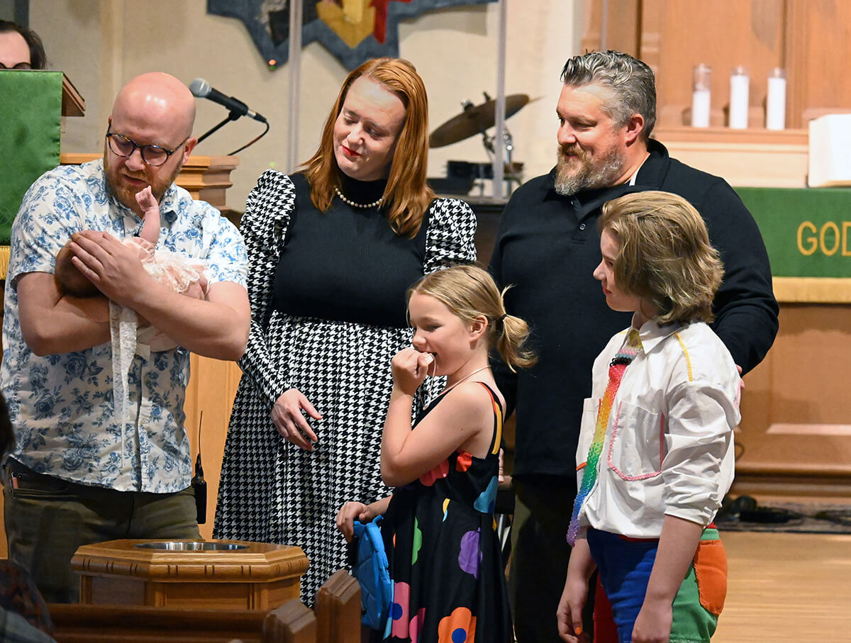 The Rev. Joe Graves (left) baptizes a baby Sept. 21 at Cityview Church. The rest of the McKinley family also were baptized during the service. Graves helped launch Cityview, a merger between his 2017 church start Central City Church and the more traditional St. Luke’s United Methodist Church. He’s also written a book on church planting, a priority of the East and West Ohio conferences. Photo by Jim Patterson, UM News.