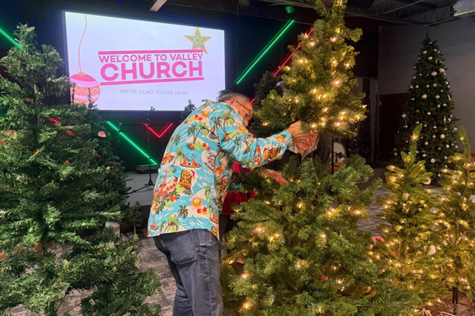 Valley Church member Joe Denson helps a family test the lights on a tree. Denson’s United Methodist church in Allendale, Mich., hosts an artificial “tree farm” every year. Photo by Lilla Marigza, UM News.
