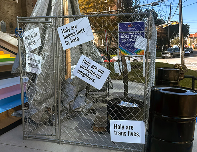 Messages offering support for transgender and unsheltered people hang on the side of a Nativity display at Oak Lawn United Methodist Church in Dallas. The structure is meant to signify an internment camp where the Holy Family is being held to protest the treatment of immigrants in the United States. Photo courtesy of Oak Lawn United Methodist Church.