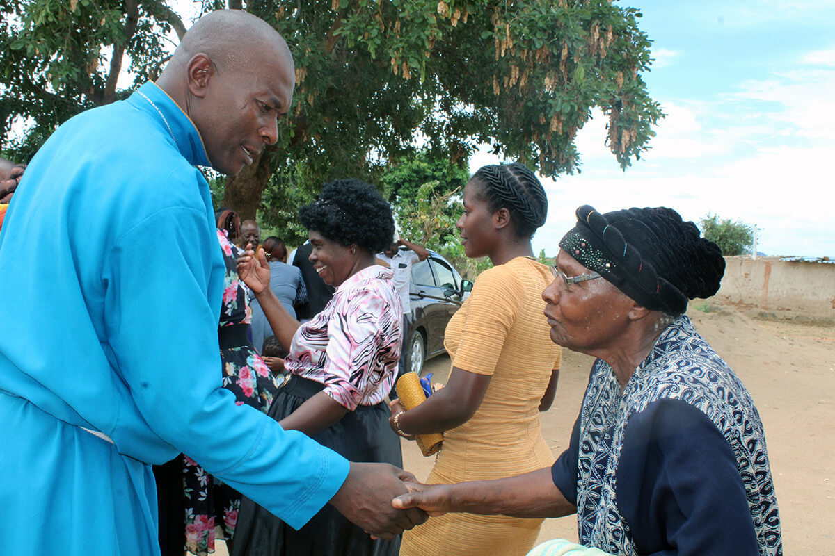 Pastor Zondai Chifamba greets Florida Sibiya after services at United Methodist Birchenough Local Church in Birchenough, Zimbabwe. Sibiya, a retired nurse and longtime member of the congregation, donated money to build a permanent sanctuary after decades worshipping under a tree. Photo by Kudzai Chingwe, UM News. 