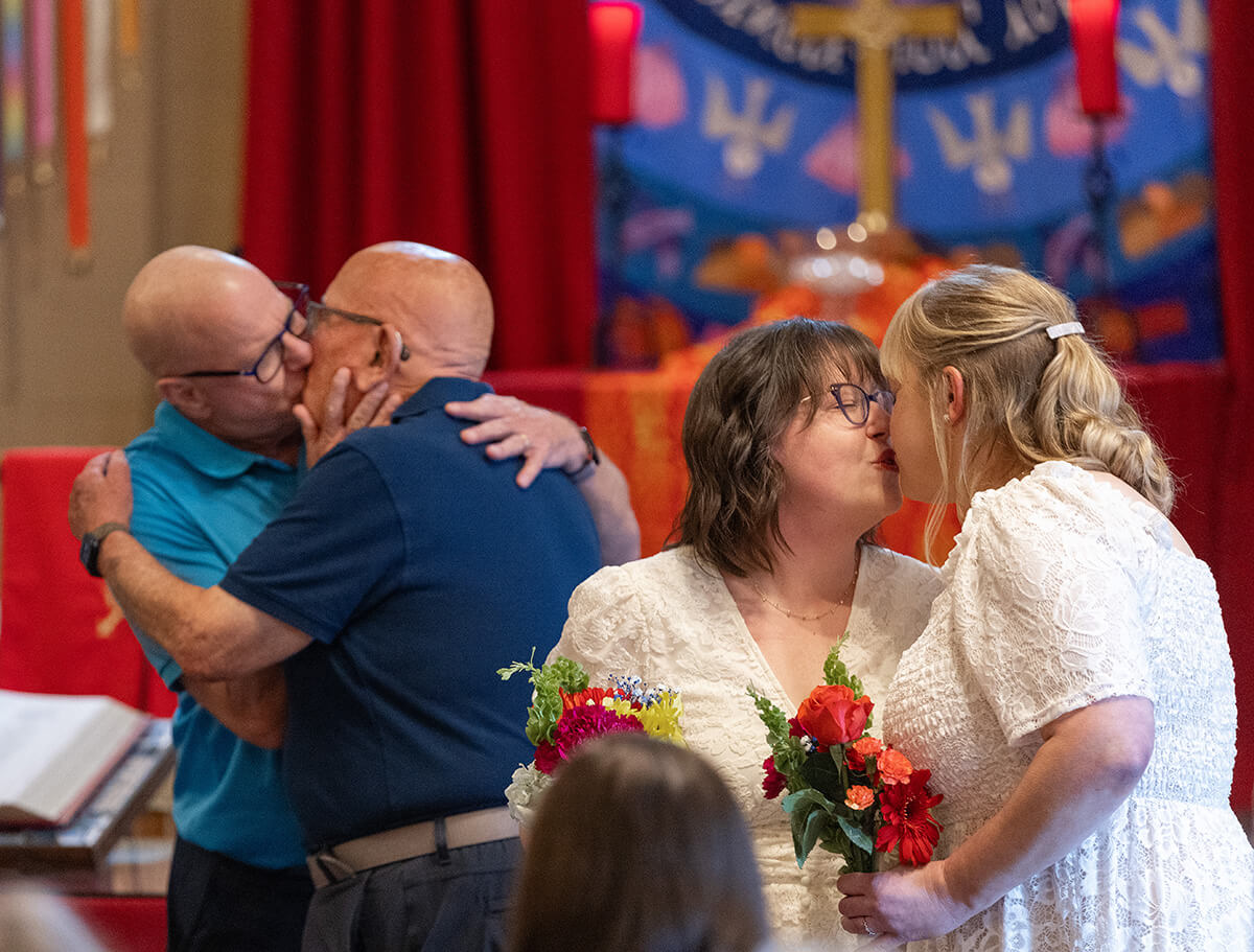 Couples kiss after renewing their wedding vows at Edgehill United Methodist Church in Nashville, Tenn. From left are John Brown, the Rev. Deen Thompson, Lindsey Dye and Laura Smotherman. Photo by Mike DuBose, UM News.